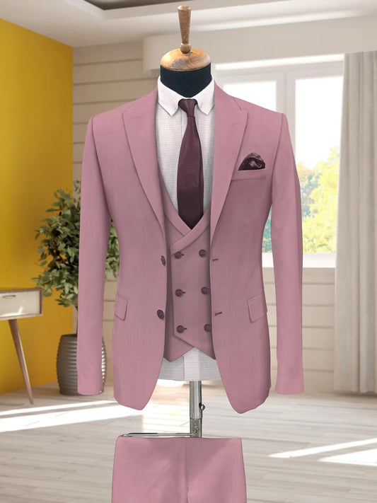 Pink suit on a mannequin against a bright yellow wall with a window in the background.